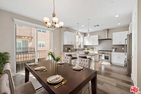 a view of a dining room with furniture a chandelier and wooden floor
