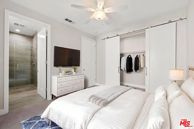 a bedroom with a bed and a flat screen tv
