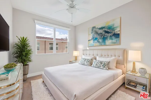 a bedroom with bed and a potted plant