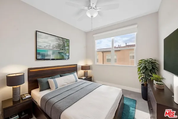 a bedroom with a bed and a potted plant