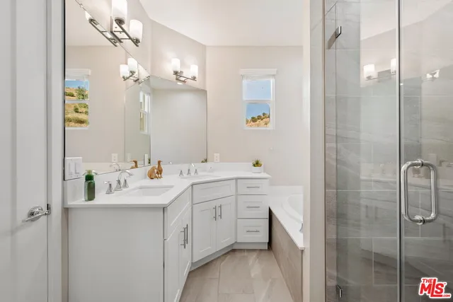 a bathroom with a double vanity sink mirror and shower