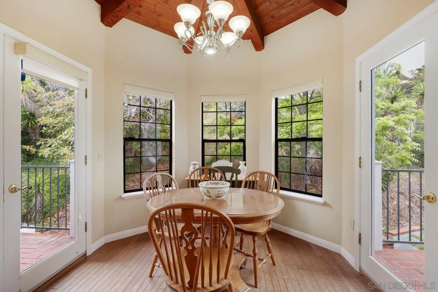 3944 Pala Mesa Drive Fallbrook, CA 92028 - Photo 18 of 39 a dining room with wooden floor a chandelier a glass table and chairs