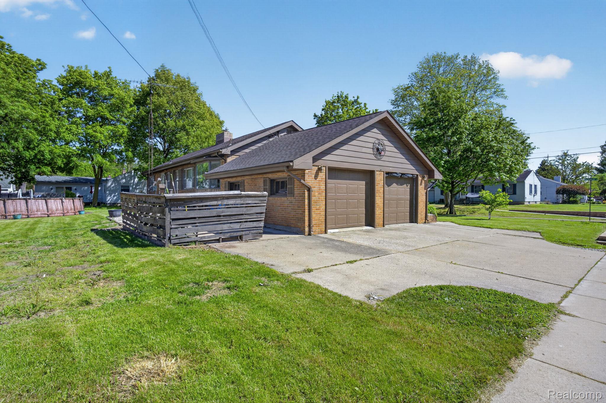 1209 Beatrice Street Flushing, MI 48433 - Photo 33 of 39 View of property exterior with brick siding, a lawn, and a chimney