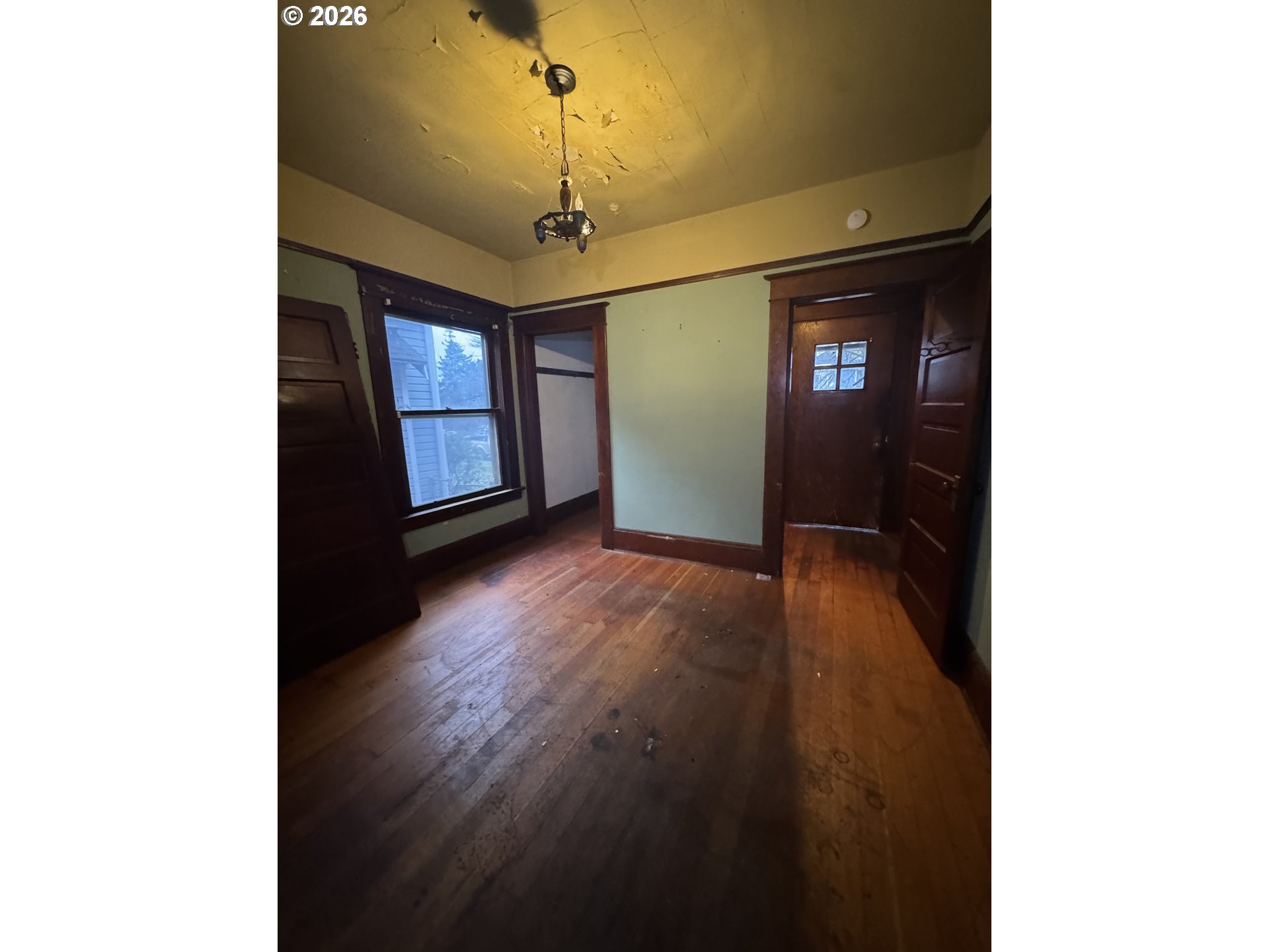 6422 Southeast Carlton Street Portland, OR 97206 - Photo 6 of 27 a view of a hallway with wooden floor and chandelier