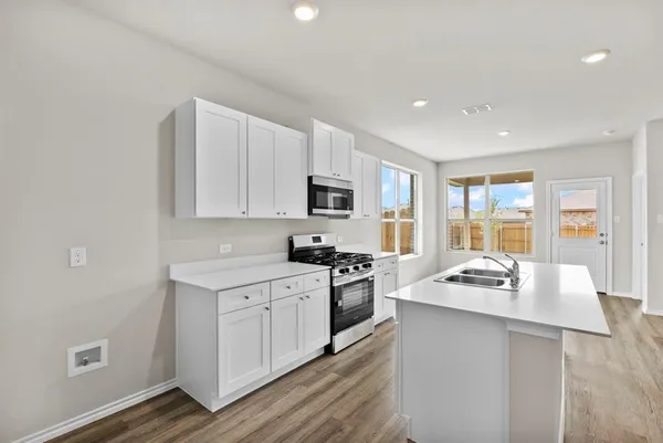 a kitchen with a sink stove top oven and refrigerator