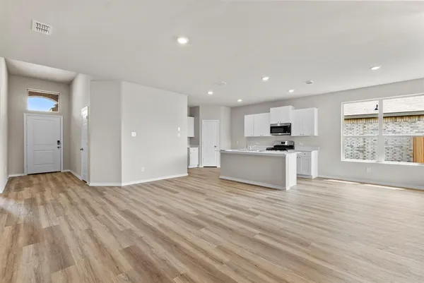 a view of kitchen with granite countertop cabinets and refrigerator