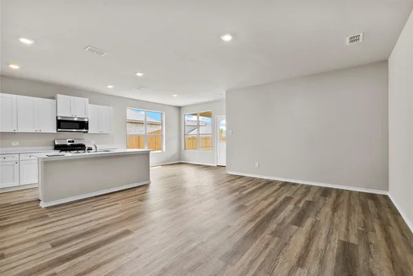 a view of kitchen with wooden floor and electronic appliances