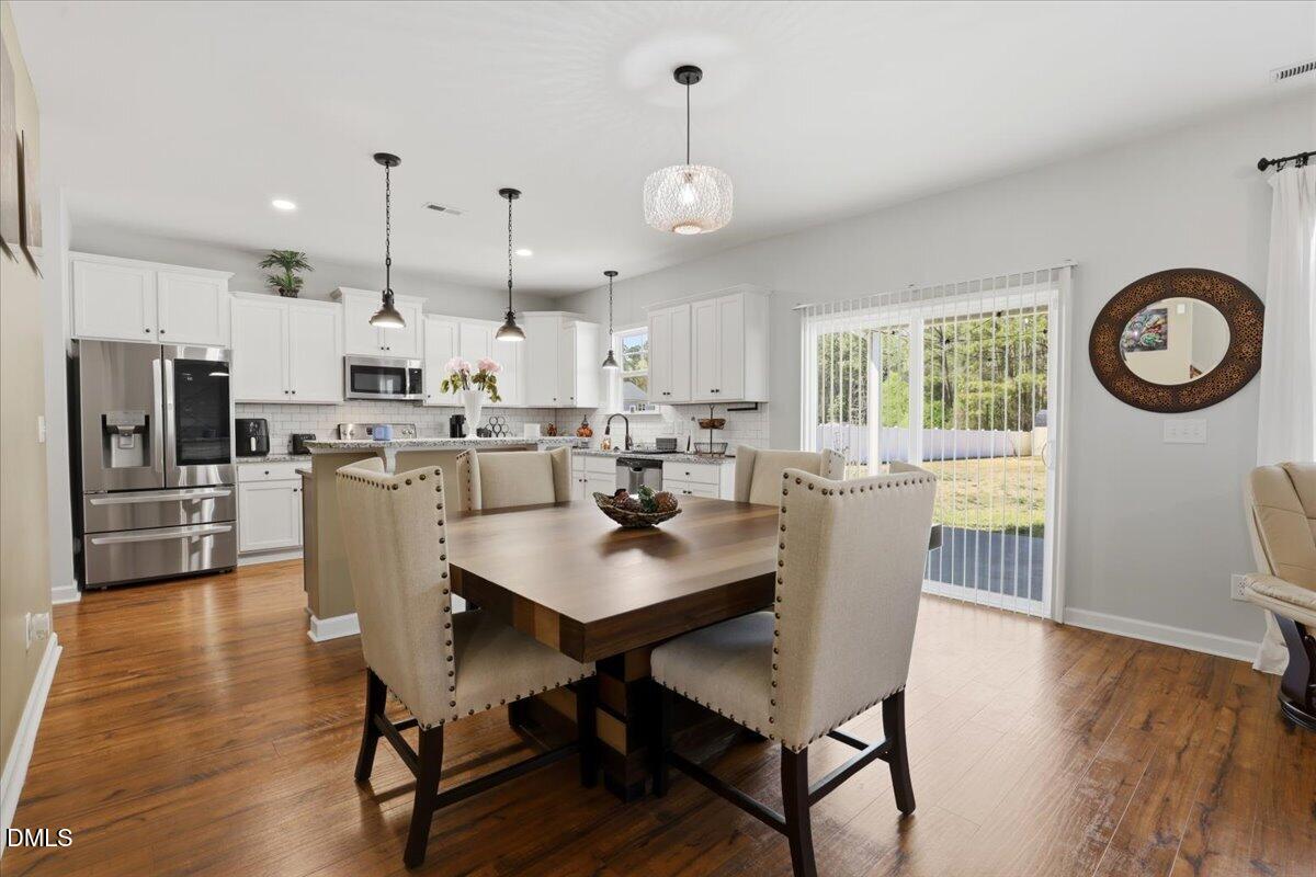 136 Fallingbrook Drive Kenly, NC 27542 - Photo 13 of 54 a view of a dining room and livingroom with furniture wooden floor a chandelier