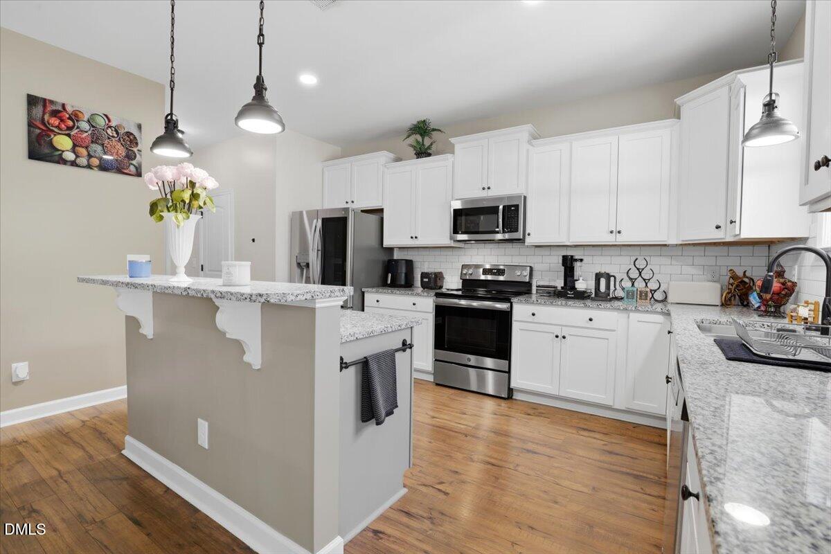 136 Fallingbrook Drive Kenly, NC 27542 - Photo 18 of 54 a kitchen with kitchen island granite countertop a sink a counter top space appliances and cabinets