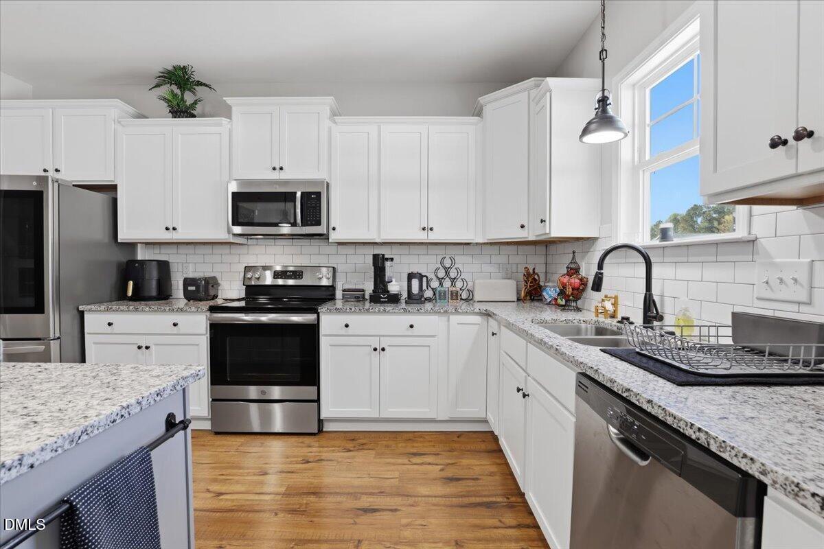 136 Fallingbrook Drive Kenly, NC 27542 - Photo 19 of 54 a kitchen with granite countertop a sink stove and white cabinets