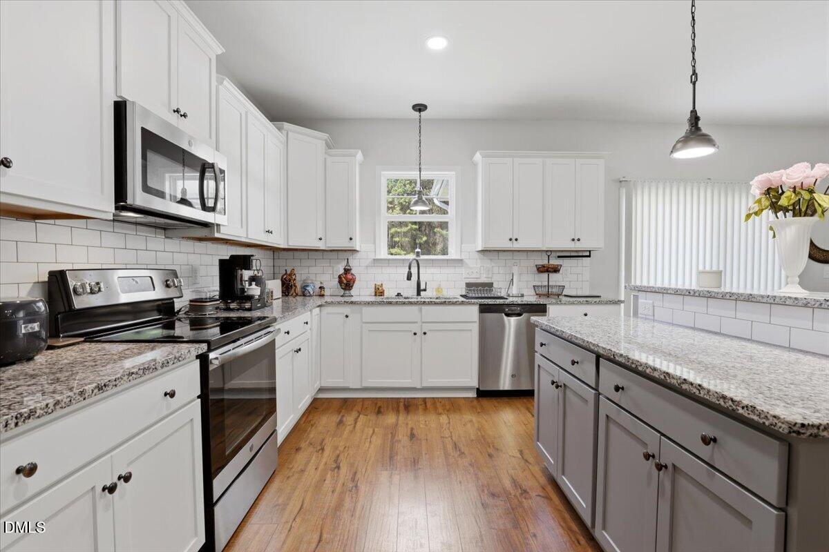 136 Fallingbrook Drive Kenly, NC 27542 - Photo 21 of 54 a kitchen with granite countertop stainless steel appliances cabinets a sink and a hard wood floor