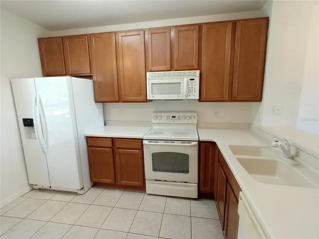 a kitchen with a refrigerator sink and cabinets