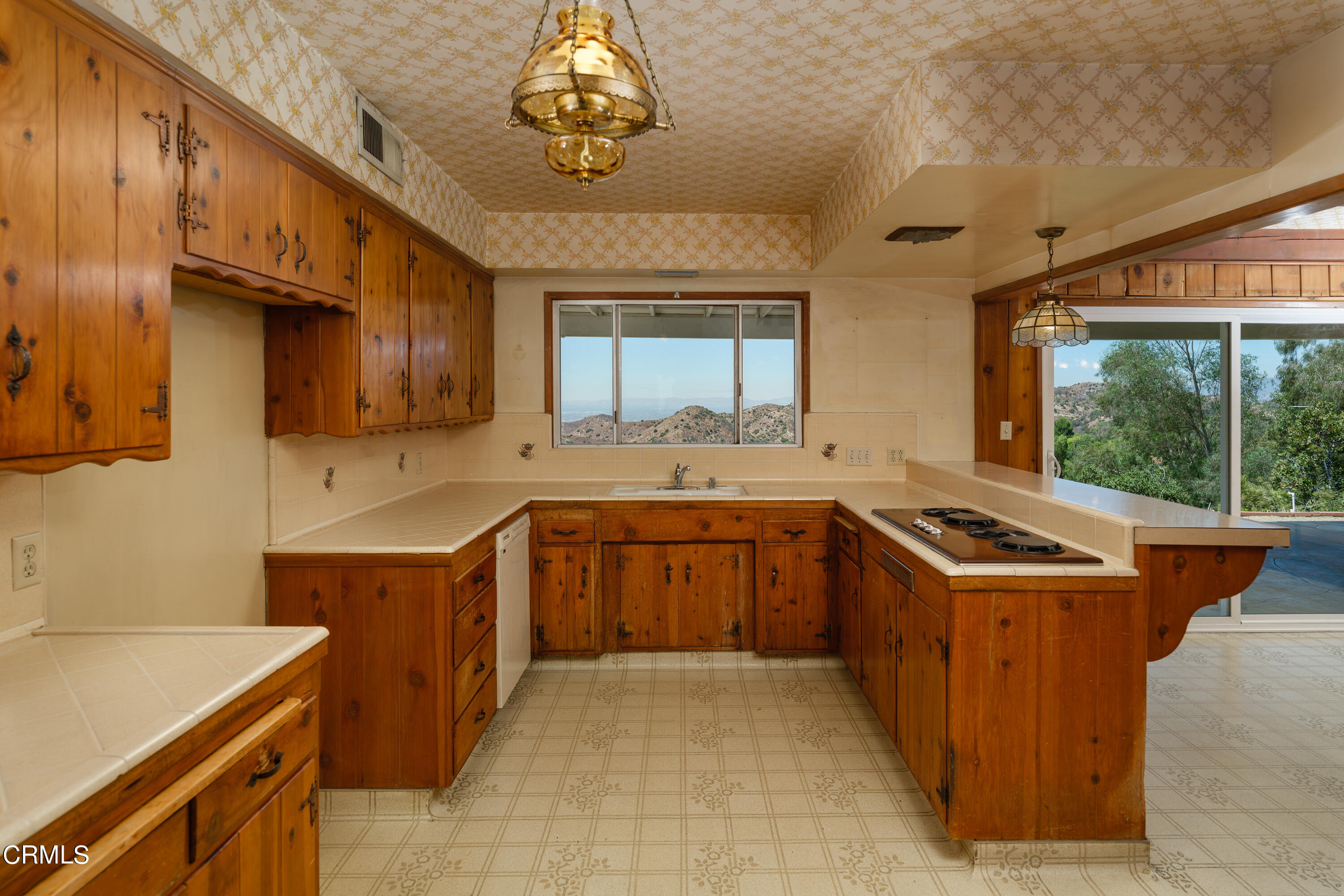 7162 Estepa Drive Tujunga, CA 91042 - Photo 16 of 43 a kitchen with a stove a sink a refrigerator and wooden cabinets