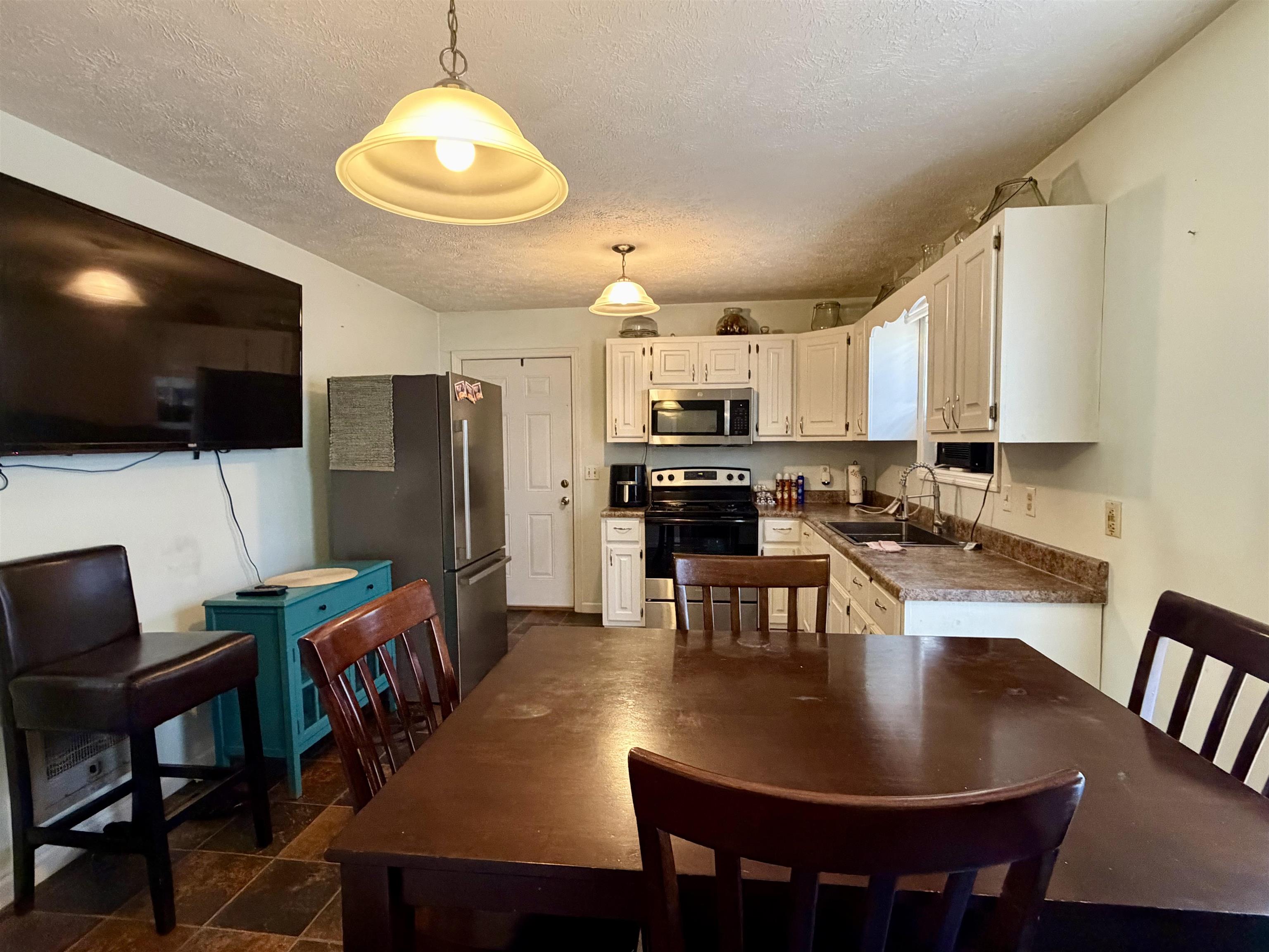 82 Shane Lane Ramer, TN 38367 - Photo 2 of 18 a kitchen with kitchen island granite countertop a dining table chairs stainless steel appliances and cabinets