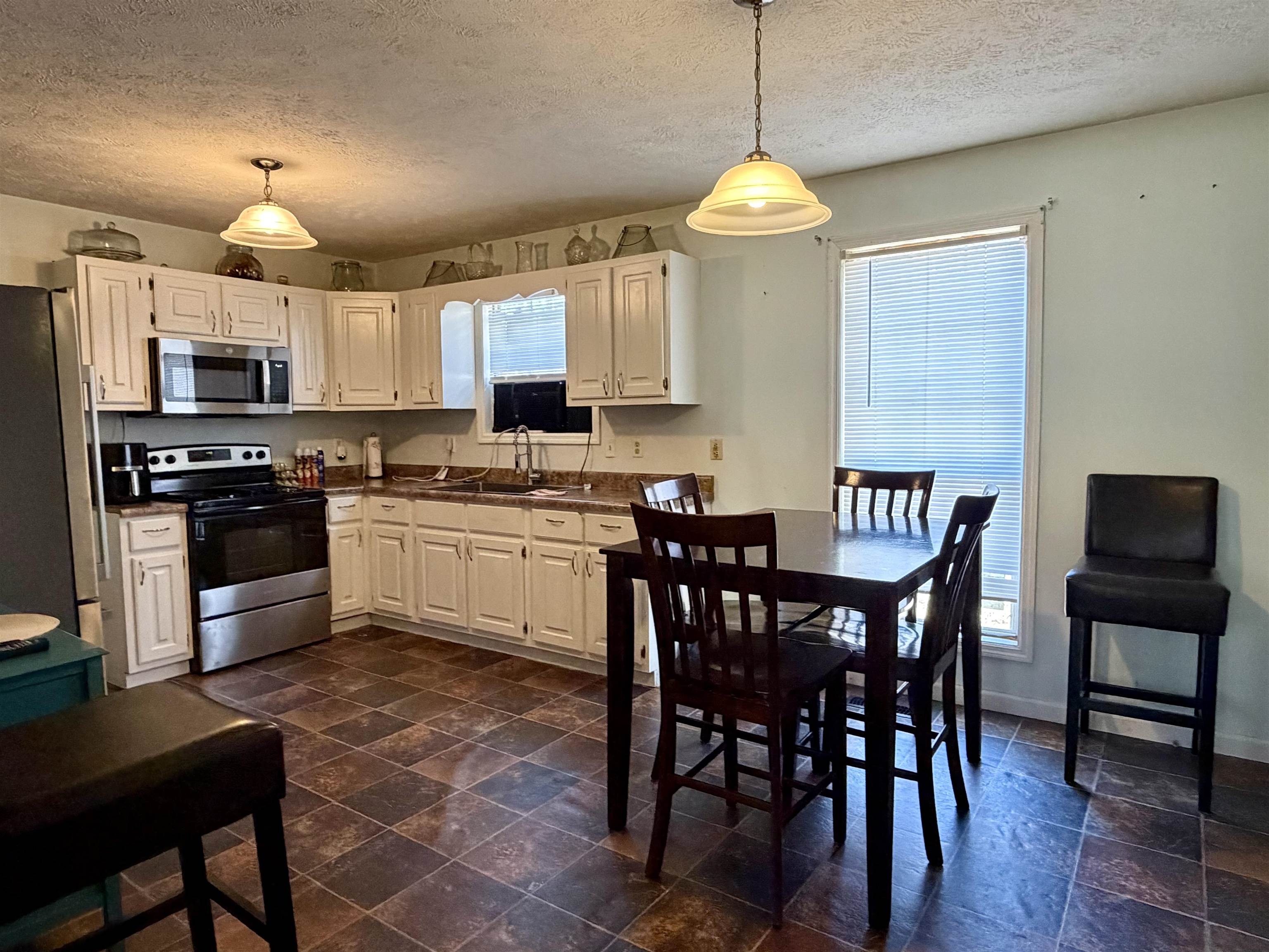 82 Shane Lane Ramer, TN 38367 - Photo 6 of 18 a kitchen with stainless steel appliances granite countertop a sink a stove a table and chairs