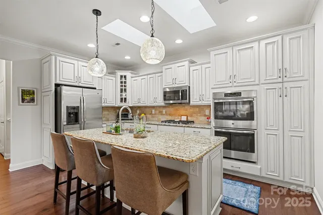 a kitchen with stainless steel appliances granite countertop a stove refrigerator and cabinets