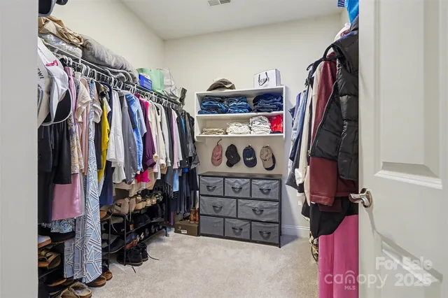 a view of walk in closet with clothes and shoes