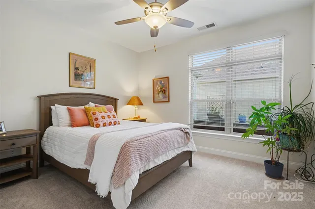 a spacious bedroom with a bed and a potted plant