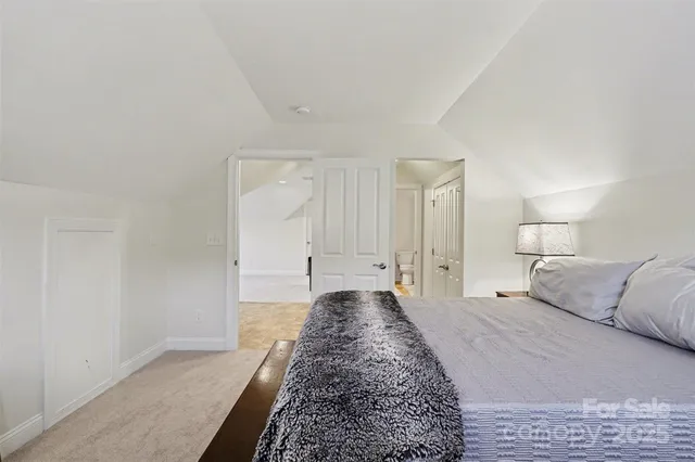 a view of a bedroom with wooden floor and window