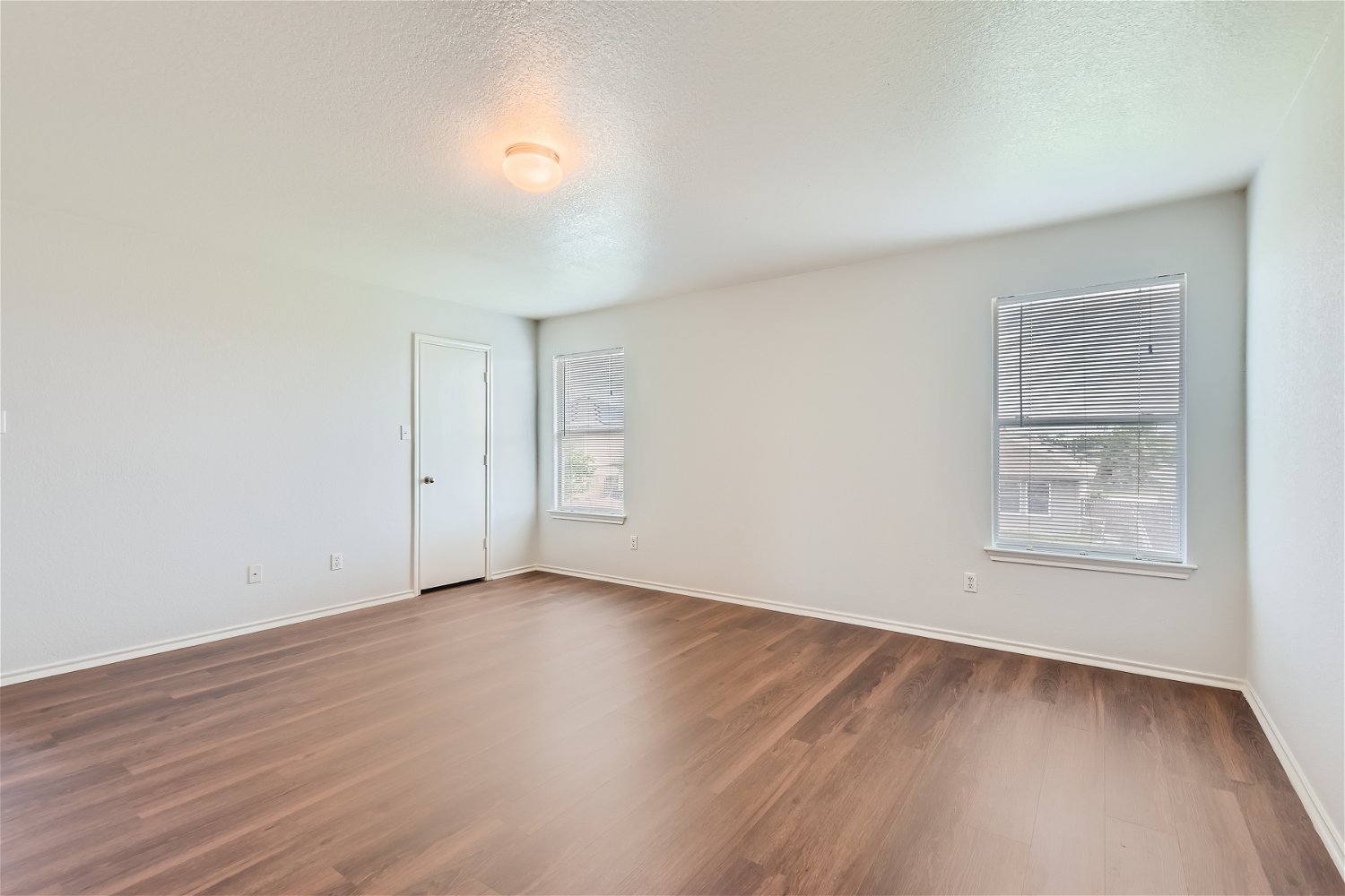 18408 Cloudmore Lane Elgin, TX 78621 - Photo 6 of 11 Laminate flooring and twin windows frame this versatile, naturally illuminated room.