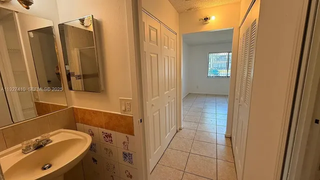 a bathroom with a granite countertop sink a mirror and a shower