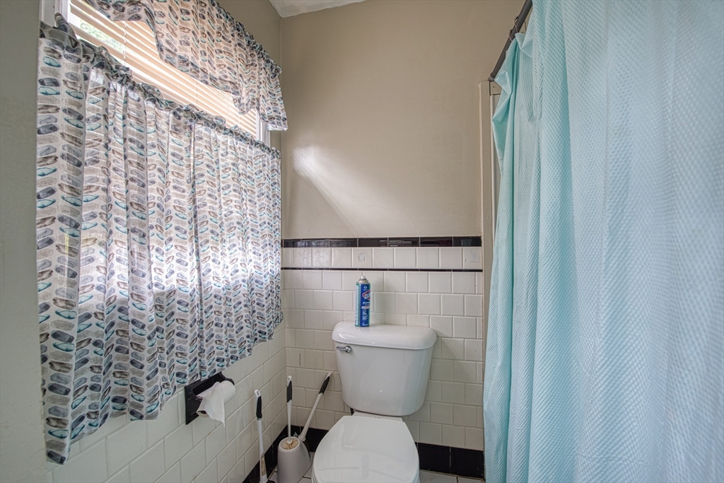 499 Maple Street Fall River, MA 02720 - Photo 13 of 21 a bathroom with a toilet and a shower curtain