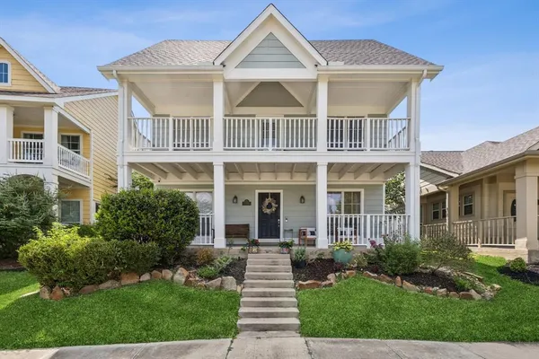 a front view of a house with a yard and potted plants