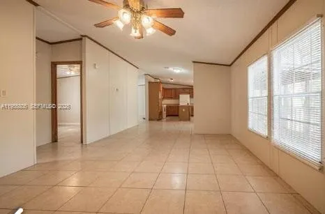 a view of a livingroom with a chandelier fan and windows