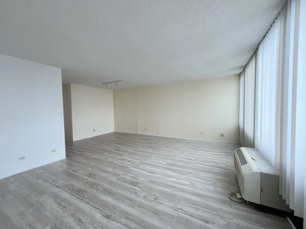 a view of room and bedroom with wooden floor