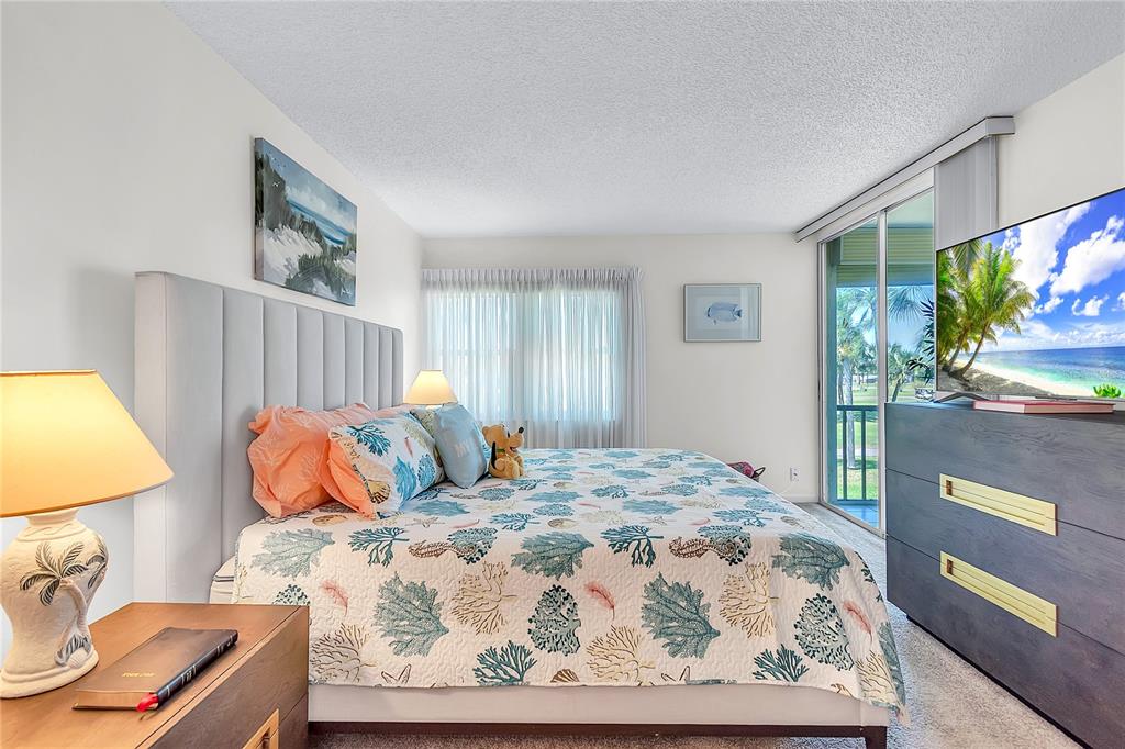 12200 Vonn Road, Unit 2206 Largo, FL 33774 - Photo 31 of 60 a bedroom with a bed and dresser with mirror
