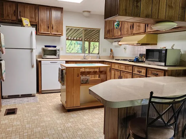 a kitchen with stainless steel appliances a stove a refrigerator and a sink