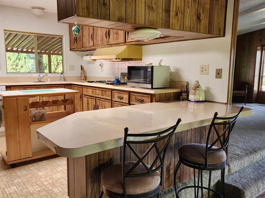 18218 Paradise Mountain Road Valley Center, CA 92082 - Photo 16 of 32 a kitchen with stainless steel appliances kitchen island a table and chairs in it