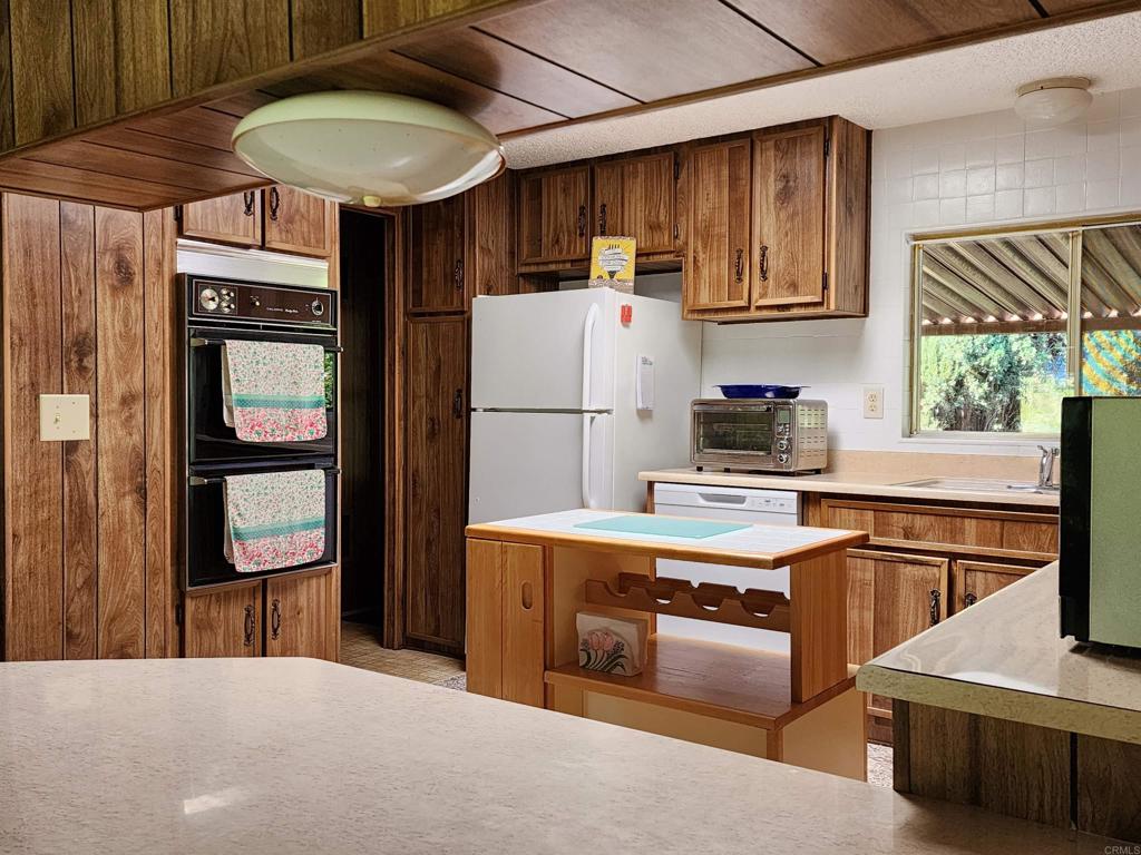 18218 Paradise Mountain Road Valley Center, CA 92082 - Photo 17 of 32 a kitchen with stainless steel appliances a stove a refrigerator and a sink
