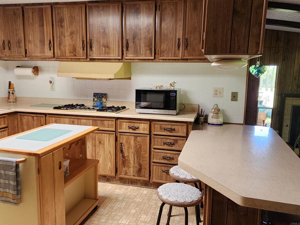 18218 Paradise Mountain Road Valley Center, CA 92082 - Photo 18 of 32 a kitchen with a stove a sink and a refrigerator