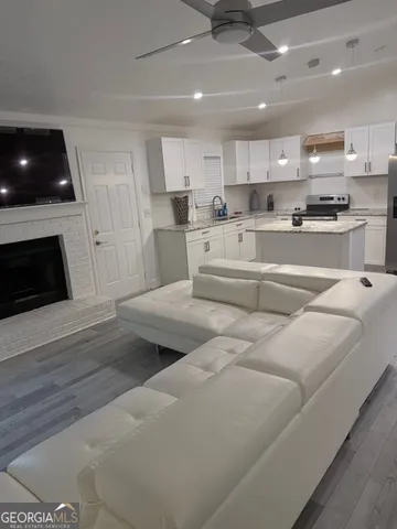 a large white kitchen with lots of counter space wooden floor and appliances