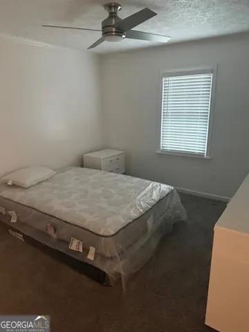 a bed sitting in a bedroom next to a window