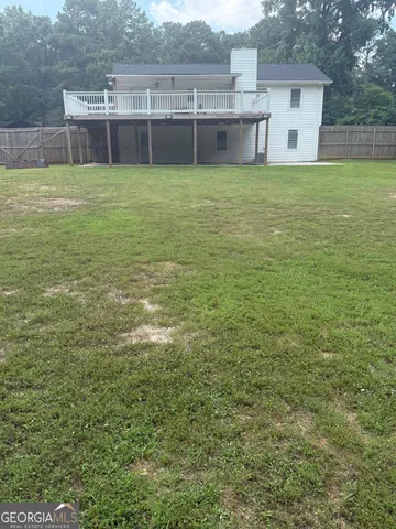 a view of a house with a yard and a large tree