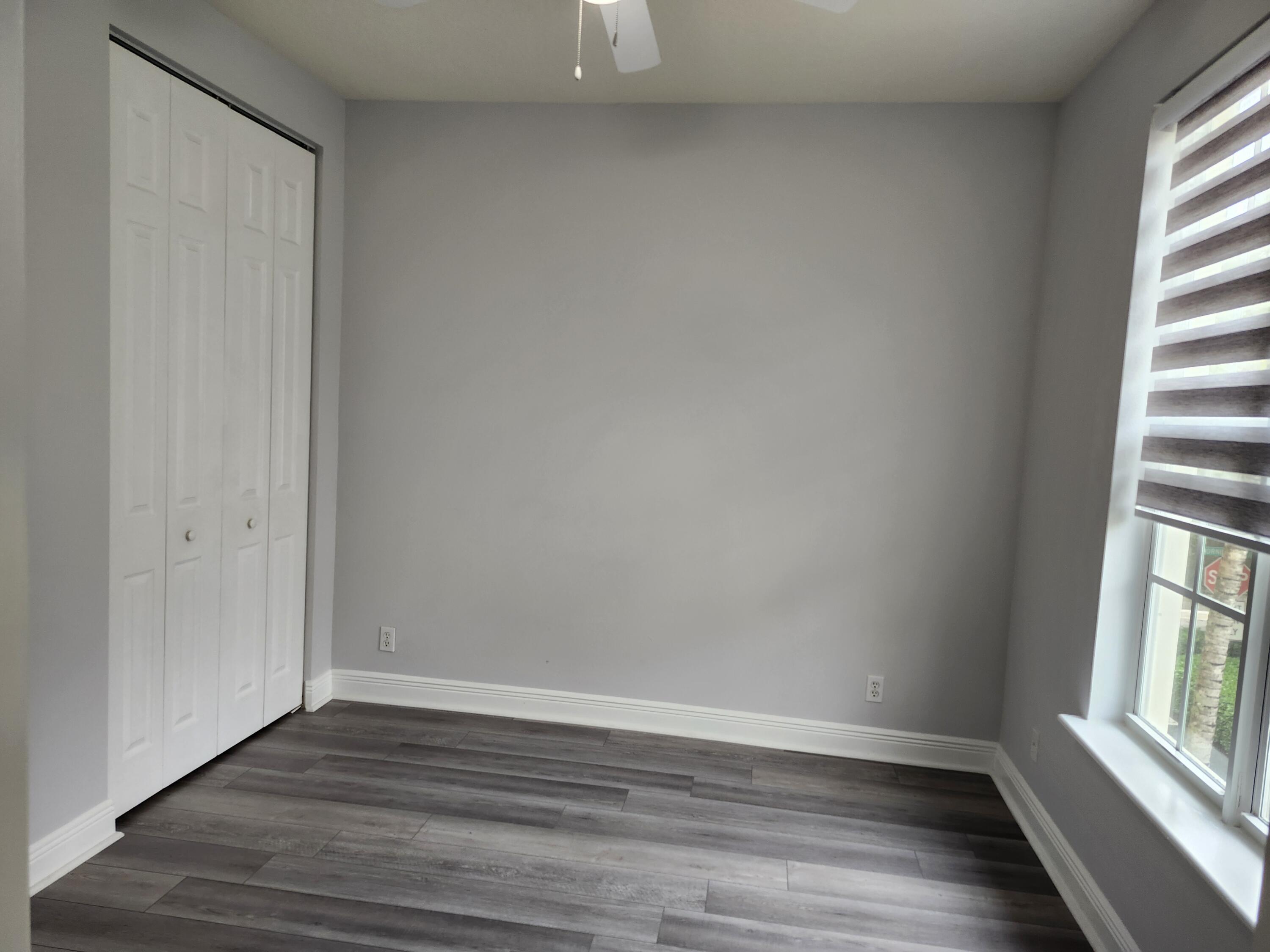 108 Morning Dew Circle Jupiter, FL 33458 - Photo 16 of 46 a view of an empty room with wooden floor and a window