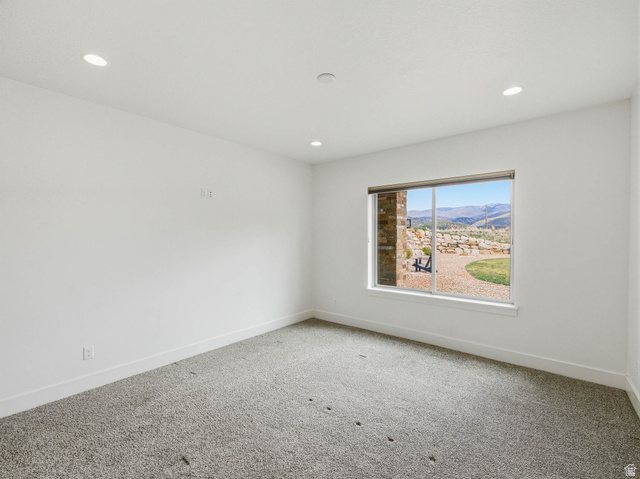 402 Shadow Hill Road Wanship, UT 84017 - Photo 58 of 90 Carpeted empty room with a mountain view and recessed lighting