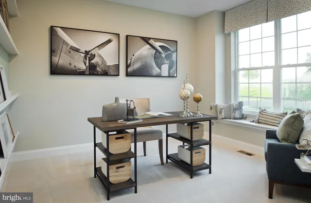 a view of a workspace with furniture and a window