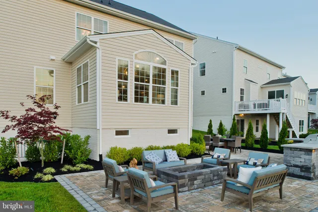 a view of a patio with table and chairs potted plants with large tree