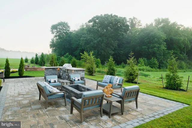 a view of a patio with couches table and chairs and potted plants