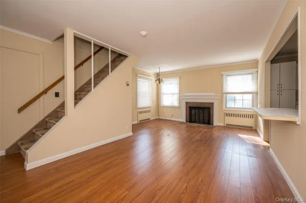 a view of empty room with wooden floor and fireplace