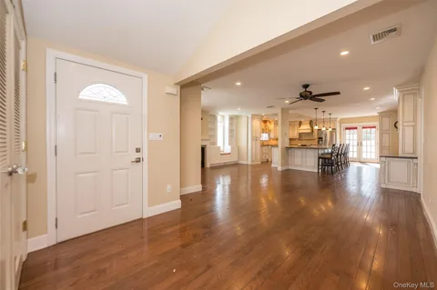 a view of a living room a kitchen and a livingroom with wooden floor