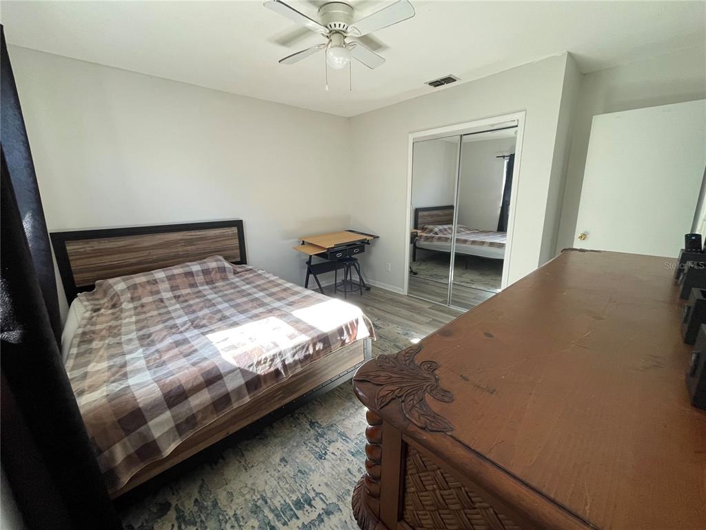 7199 121st Terrace Largo, FL 33773 - Photo 13 of 16 a bed sitting in a bedroom next to a window with pc on the table
