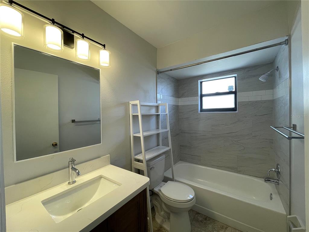 7199 121st Terrace Largo, FL 33773 - Photo 14 of 16 a bathroom with a sink mirror toilet and bathtub