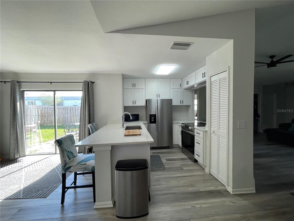 7199 121st Terrace Largo, FL 33773 - Photo 5 of 16 a kitchen with stainless steel appliances a stove a refrigerator a oven a sink with island and chairs