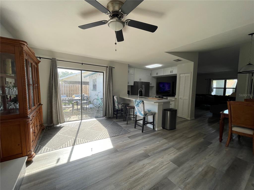 7199 121st Terrace Largo, FL 33773 - Photo 7 of 16 a living room with stainless steel appliances kitchen island granite countertop furniture a fireplace and a flat screen tv