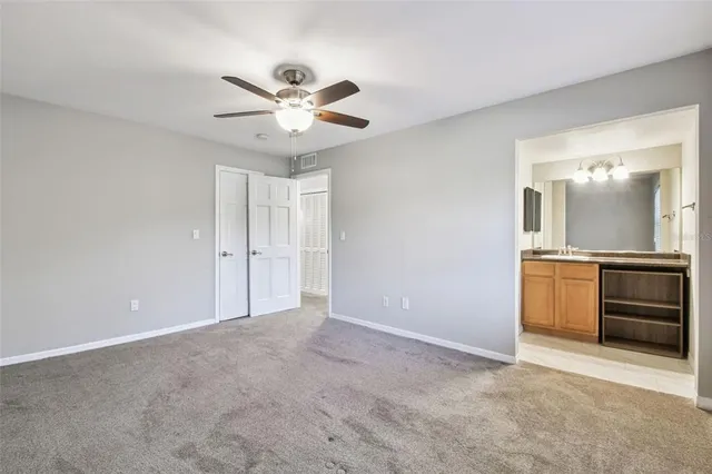 a spacious bathroom with a granite countertop toilet sink and mirror