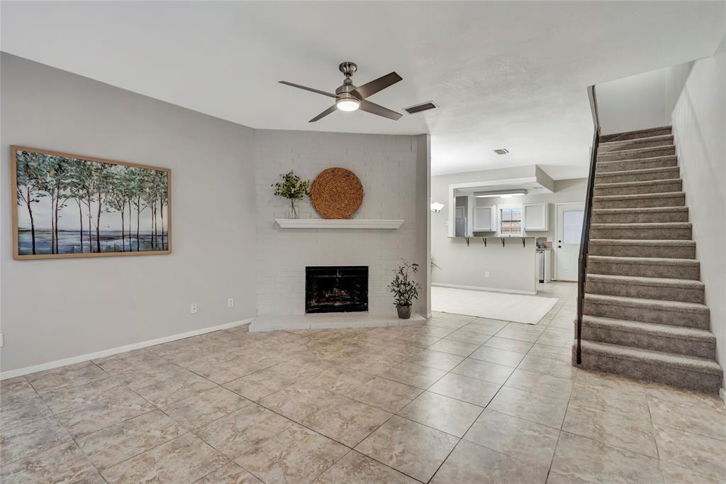 a view of a livingroom with wooden floor and a ceiling fan